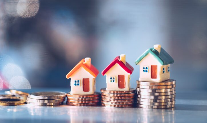 Miniature colorful house on stack coins